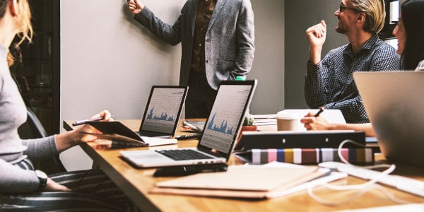 importance of time management - a meeting with laptops open and a presenter