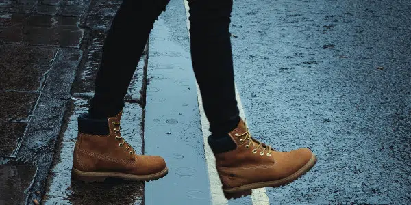time management skills - feet of a person stepping off curb to road