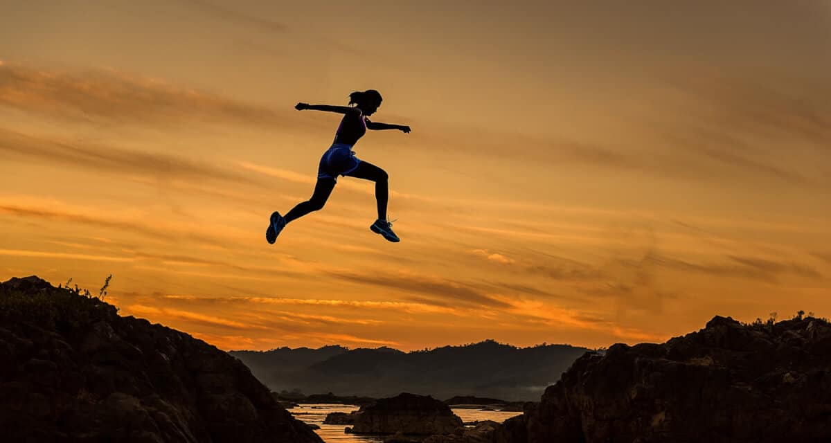 how to set goals - woman jumping over ravine